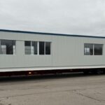 16' × 50' prefabricated electrical equipment building being transported to a jobsite